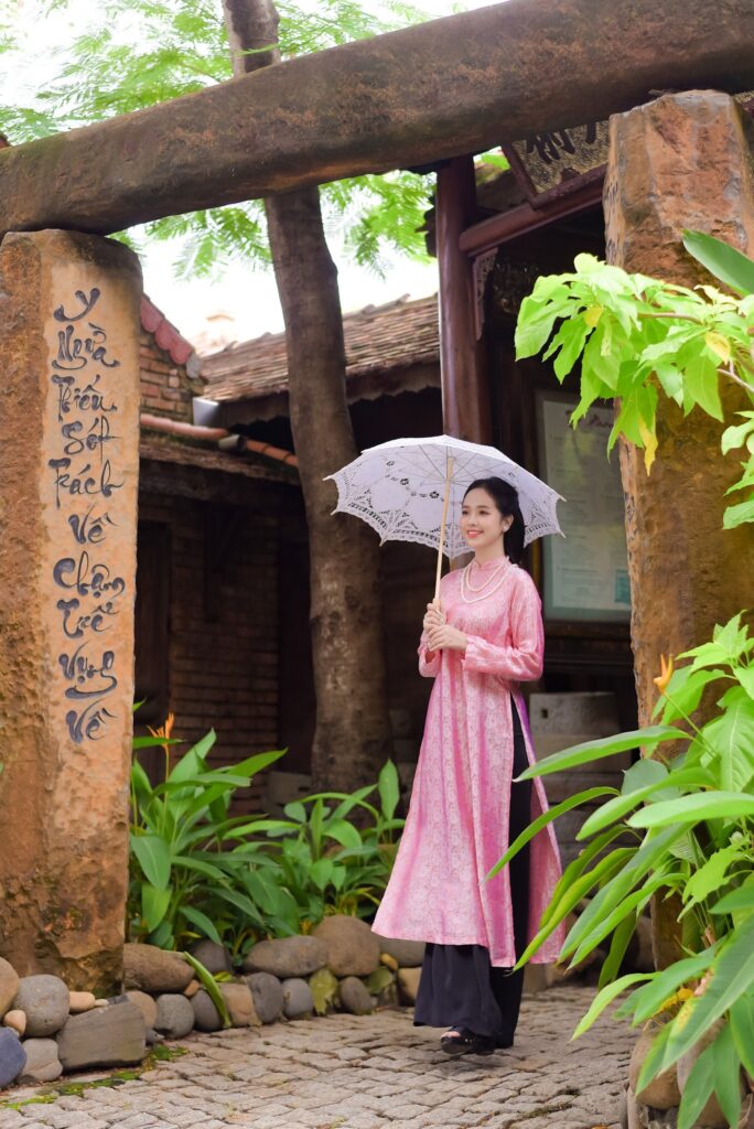 Hình ảnh một cô gái mặc áo dài truyền thống chụp ảnh trong vườn