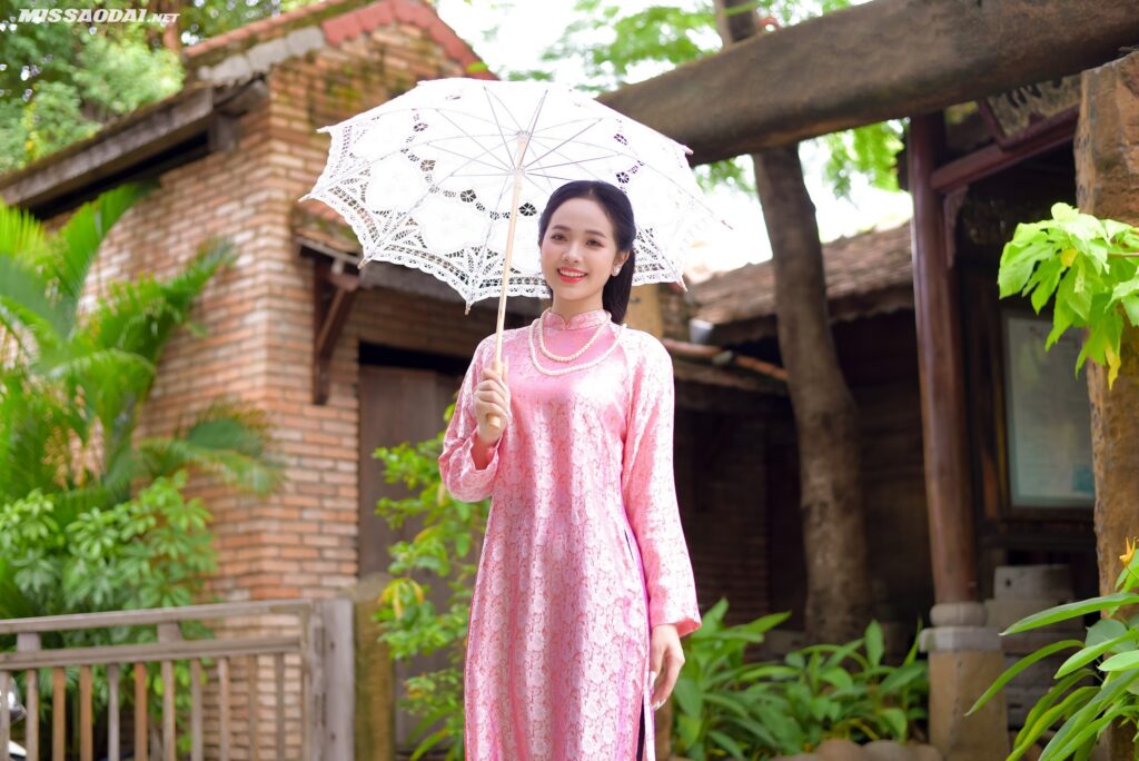 Hình ảnh một cô gái mặc áo dài truyền thống chụp ảnh trong vườn